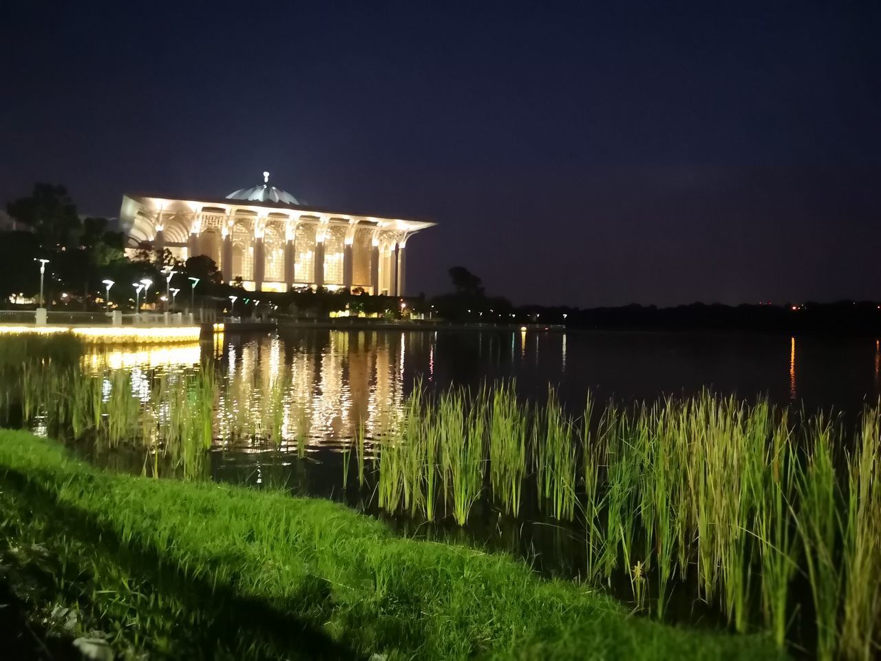 REFLECTION OF ILLUMINATED BUILDING IN WATER