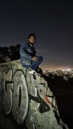 Portrait of young man standing against sky at night