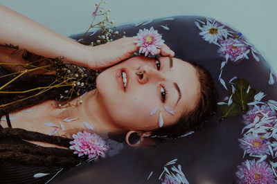 Close-up portrait of woman with pink flowers