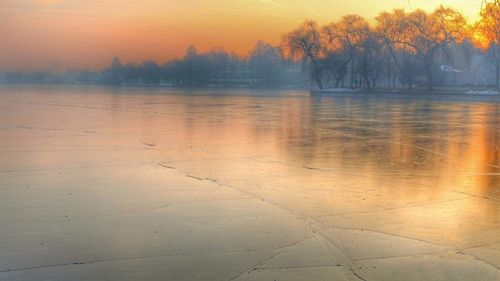 Scenic view of lake against orange sky