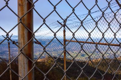 Close-up of chainlink fence against sky