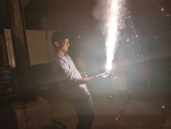 Man holding firework at night