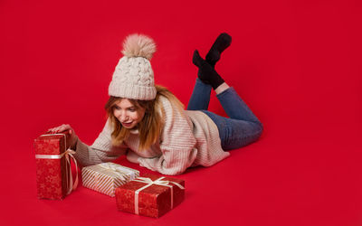 Portrait of a smiling young woman against red background