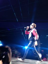 Young man dancing on stage at night