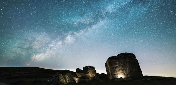Low angle view of rock formations against sky at night