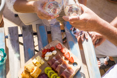 Cropped image of senior couple toasting drinks