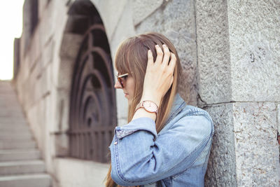 Side view of woman against wall