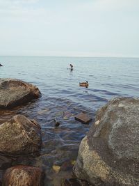 Scenic view of rocks in sea against sky