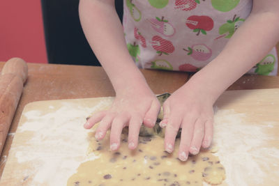 Midsection of girl preparing cookies at home