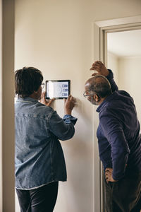 Senior couple looking at home automation on wall