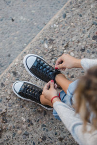 Low section of woman wearing shoes on ground