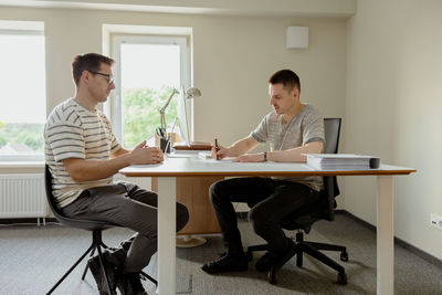 Serious professional man consulting client in office. two mens having meeting, making business