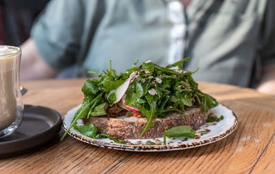 Artisan bread sandwich with arugula, radish and avocado salad. vegan breakfast.