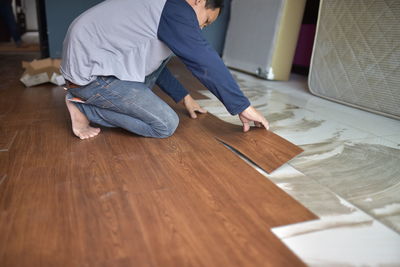 Man working on hardwood floor at home