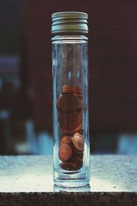 Close-up of coins in glass jar on table