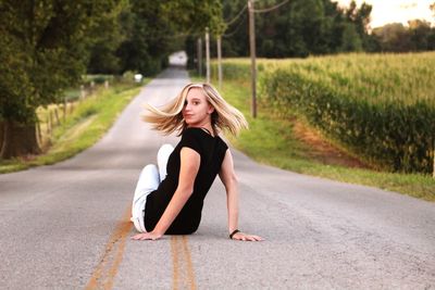 Portrait of smiling young woman on road