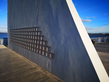 Modern building by sea against sky