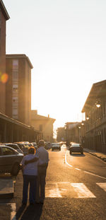 Cars on city street against clear sky