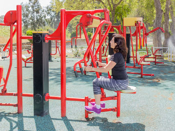 Young female athlete exercising at outdoor gym