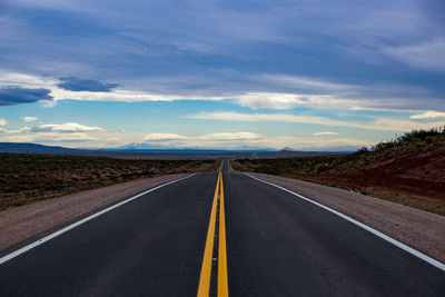 Empty road along countryside landscape