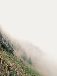 Scenic view of mountains in foggy weather against sky