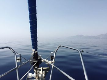 Close-up of sailboat sailing on sea against clear sky