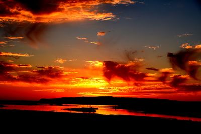 Scenic view of sea against dramatic sky during sunset