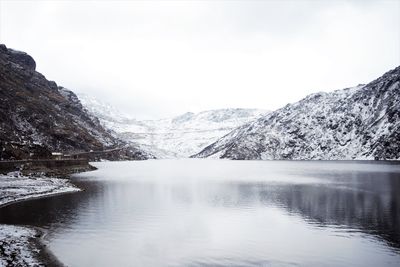 Scenic view of lake and snowcapped mountains against sky