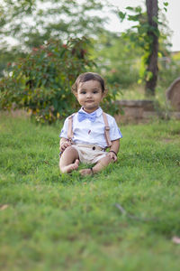 Portrait of cute boy sitting on field