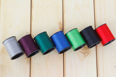 Close-up of colorful thread spools on wooden table