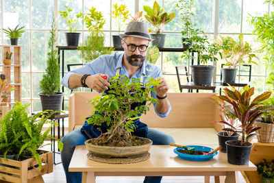 Young man holding potted plant