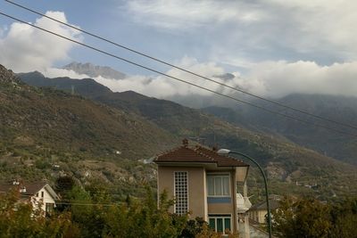 House on mountain against sky