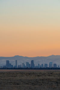 Buildings in city against clear sky during sunset