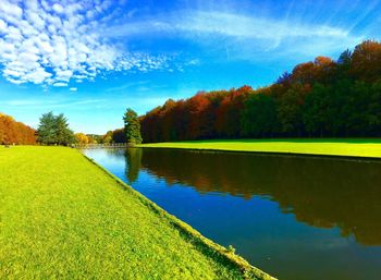 Scenic view of lake by trees against sky