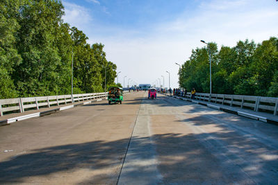 People on bridge against sky