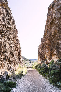 Road amidst rocks against clear sky