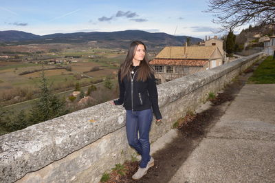 Full length of young woman looking away while standing on observation point