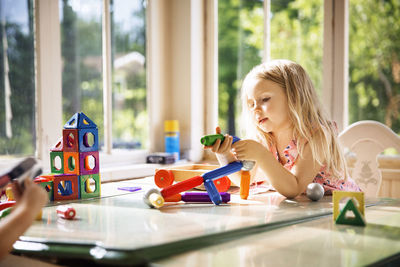 Girl playing with building blocks at home