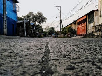 Surface level of road by houses against clear sky