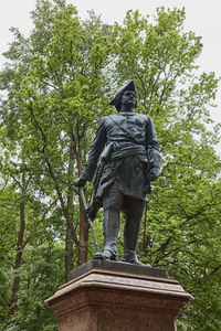 Low angle view of statue against trees