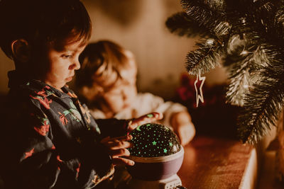 Cute boy looking at christmas decoration at home