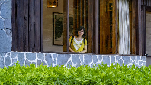 Portrait of a smiling girl standing against plants