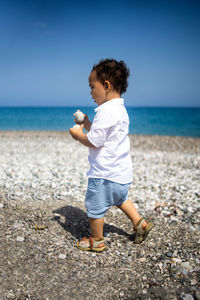 Happy kid in white shirt and blue shorts.