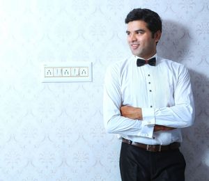 Young man standing against wall