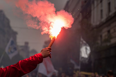Cropped hand of man holding sparkler at night