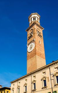 Low angle view of clock tower against blue sky