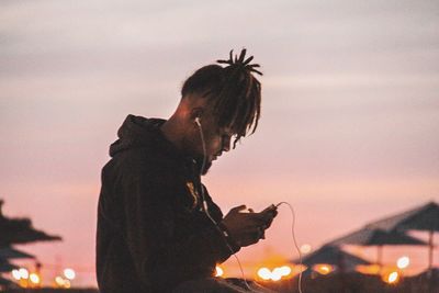 Side view of silhouette woman against sky at sunset