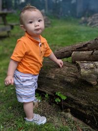 Full length portrait of cute baby boy standing in forest