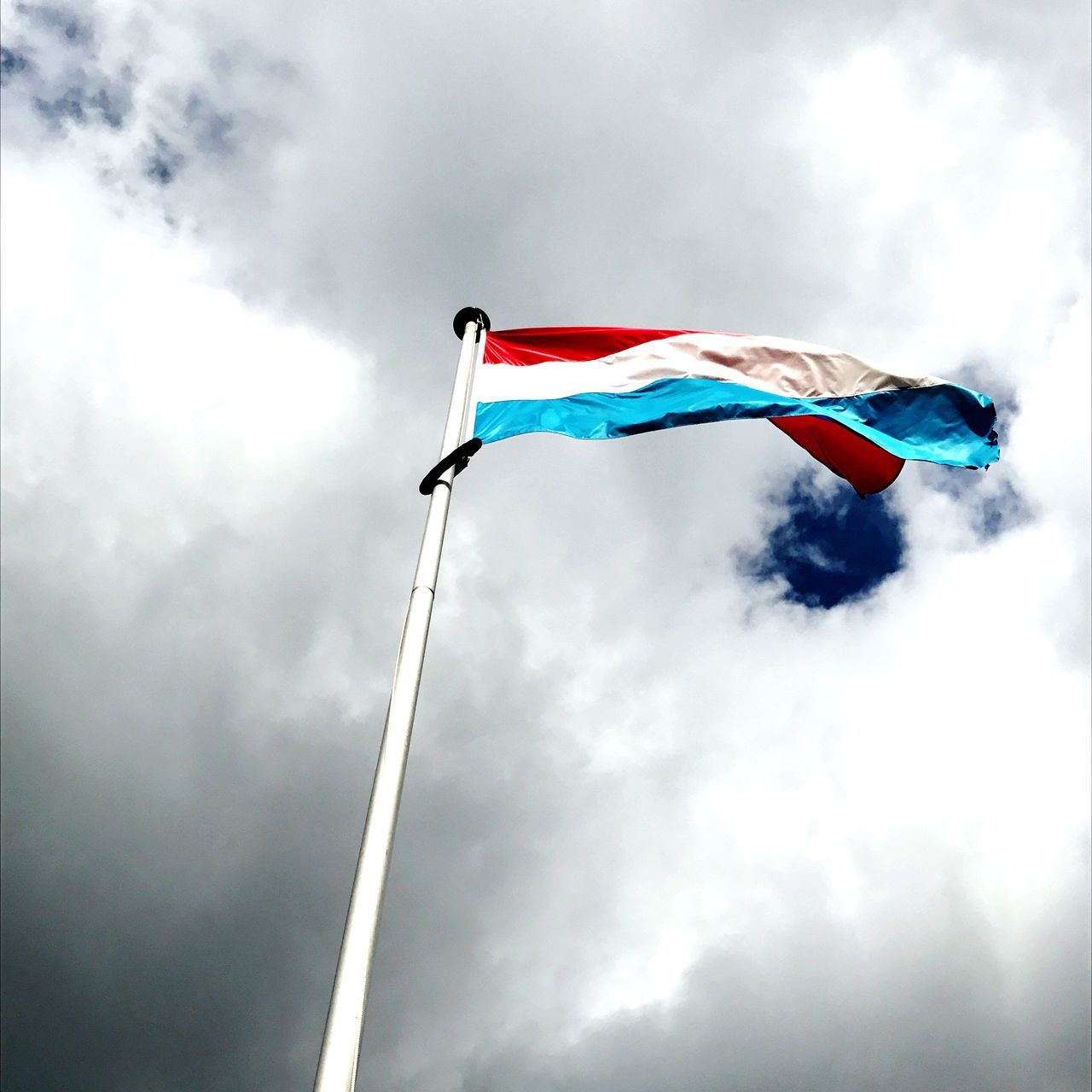 flag, low angle view, wind, patriotism, day, outdoors, sky, pride, no people