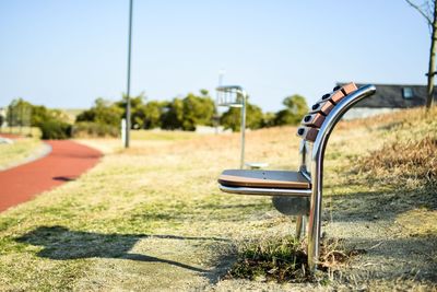 Empty park against clear sky on sunny day